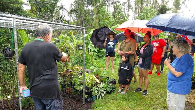 master gardener ed olsen moore showing people his garden.