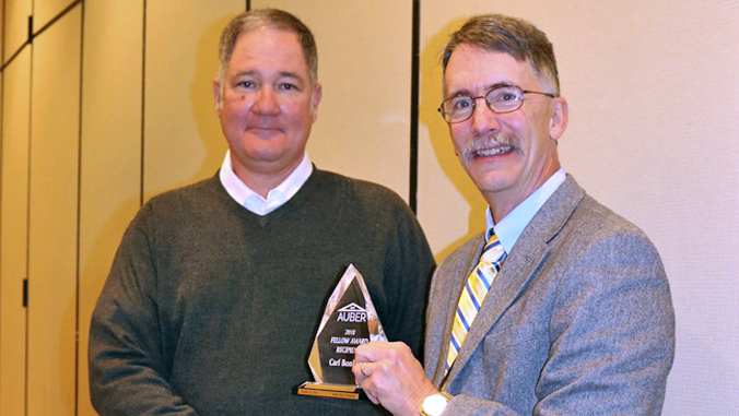 two people holding glass award