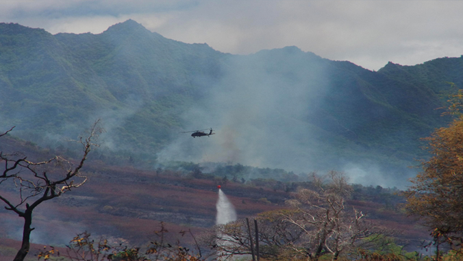 helicopter dropping water on wildfire in Hawaii