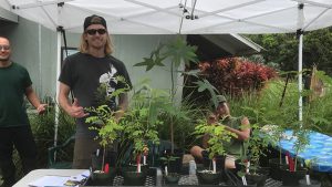 three males with various plants and trees