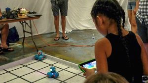 Girl controlling small robots with a tablet, click for larger image