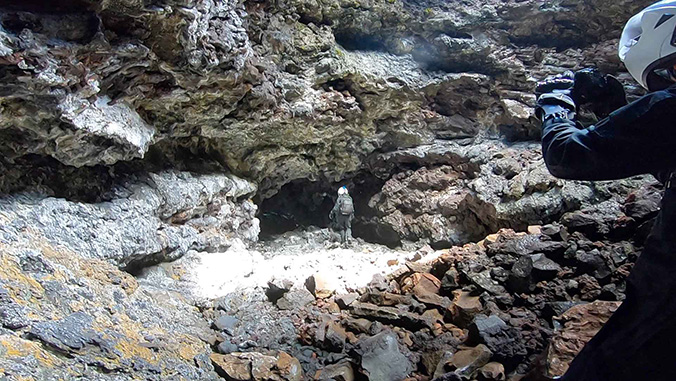 Researcher in space suit entering a cave