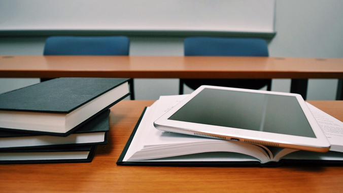 book and iPad on a desk