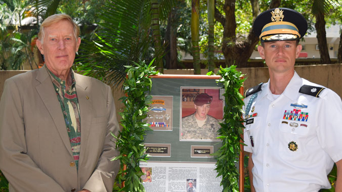 Two men flank a framed picture of Jonathan Brostrom.