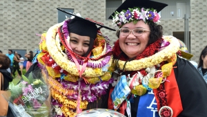 students in graduation regalia wearing lei