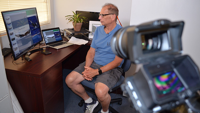 Adam pack being filmed working at a computer