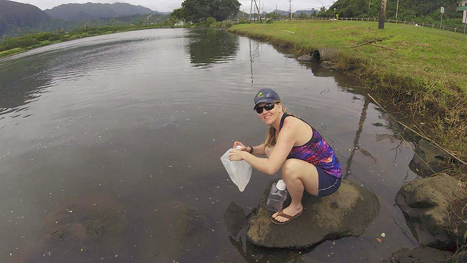 Student collecting water samples in the field