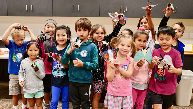 group of students holding insect art project