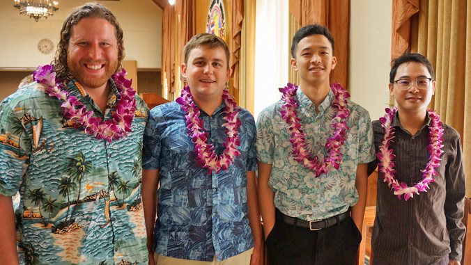 four people standing in Honolulu City Coucil wearing lei