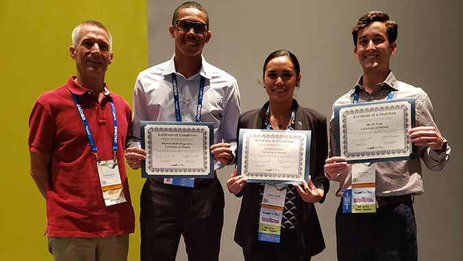 professor and three students with certificates