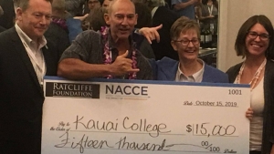 four people holding giant check