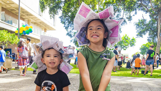 kids wearing newspaper hats