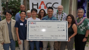 Team holding a check with Governor Ige