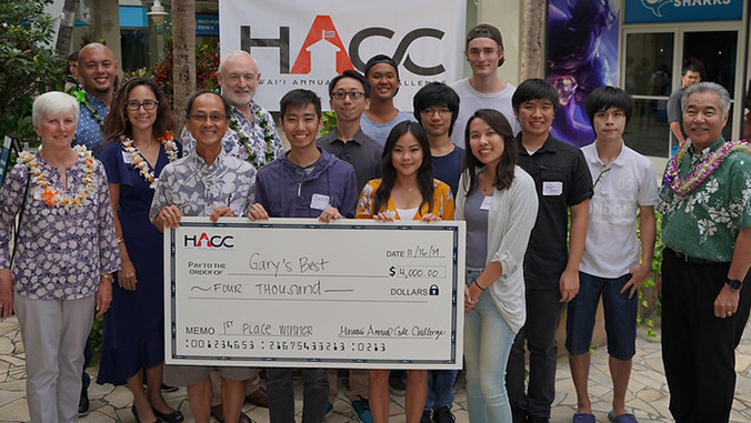 Winning team holding a check with Governor Ige