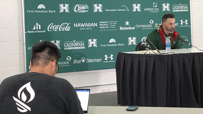 student taking notes at press conference