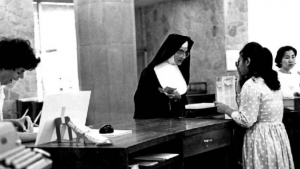 nun checking out book at front desk