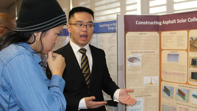 student explaining his science fair exhibit