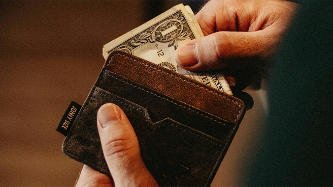 Hand taking money out of a wallet