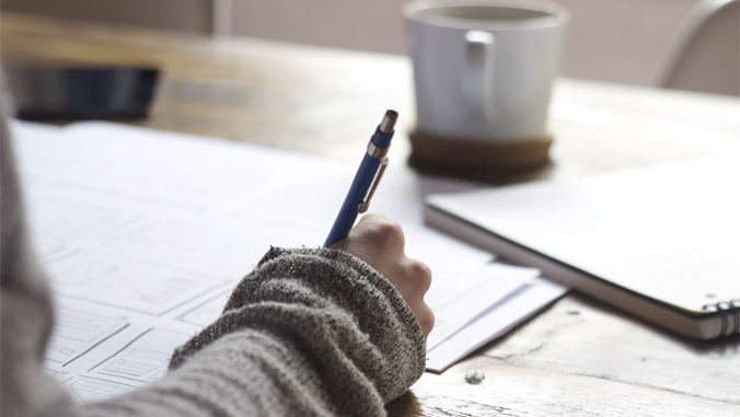 person writing using pen on paper