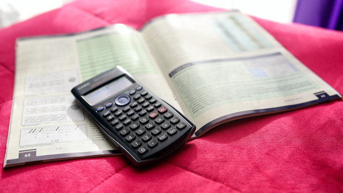 calculator and book on a table