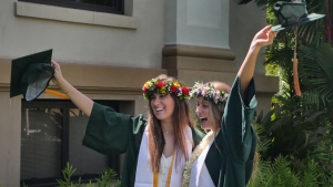 2 U H Manoa grads wearing caps and gowns