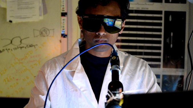 person wearing sunglasses looking at computer