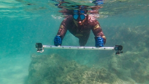 man swimming with go pros