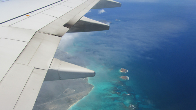 Airplane wing over the ocean