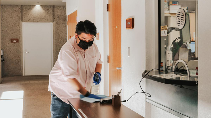 Man disinfecting a desk