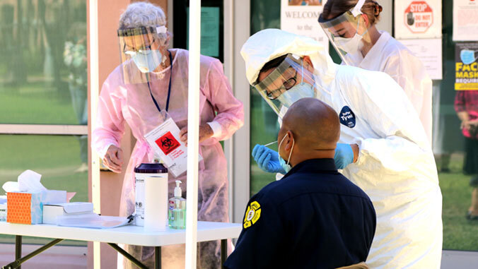 medical staff conduct covid test on fireman