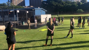 people wearing face masks talk on a soccer field