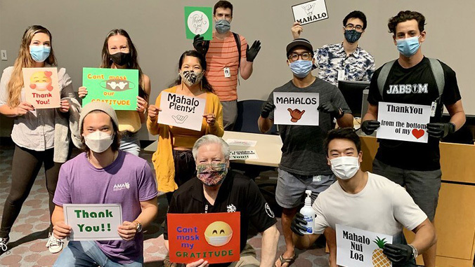 JABSOM students with masks holding up signs