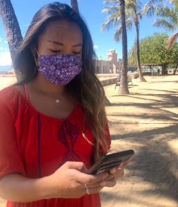 girl wearing mask mask looking at phone