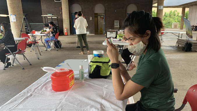 female student sitting at table with mask on