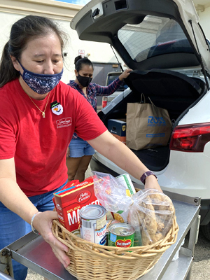 person loading food basket into back of car