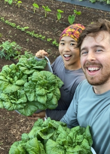 two people holding up their harvest and smiling