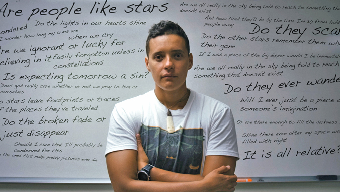 person looking into camera in front of a white board