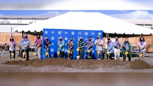 Several people shoveling a pile of dirt commemorating groundbreaking