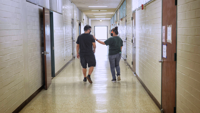 two people walking down a hallway