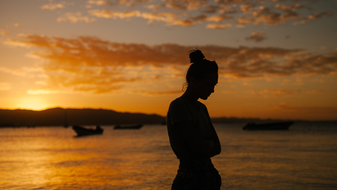 woman at beach during sunset