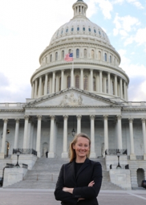 person smiling at camera standing in front of capitol