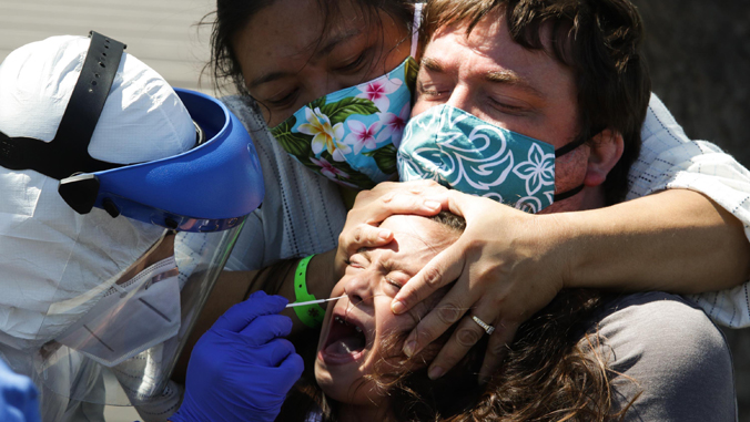 girl crying as worker swabs nose testing for COVID-19