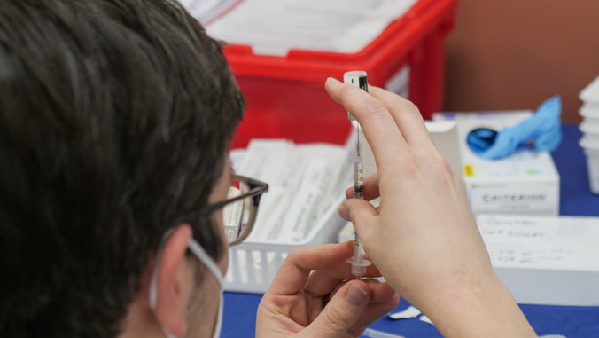 person preparing COVID-19 vaccine