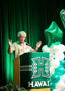 person at a podium with arms open