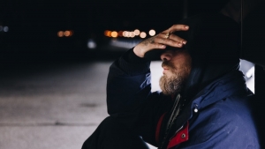man sitting with hand to head