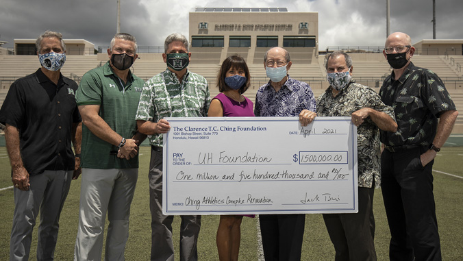 People holding check on Clarence T C Ching Field