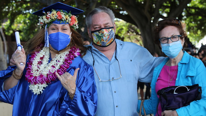 graduate with parents wearing masks