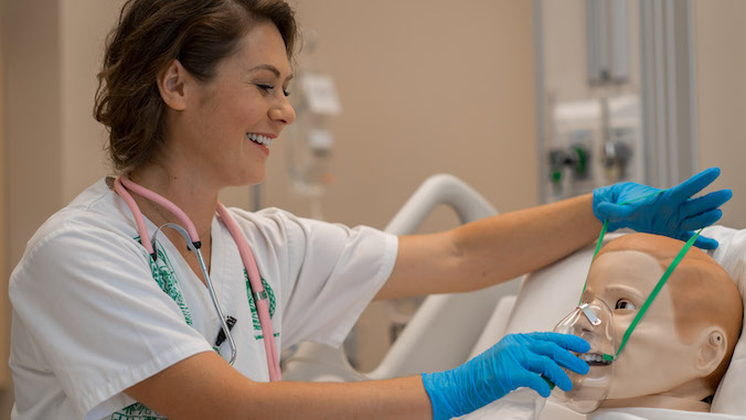 nursing student with mannequin patient