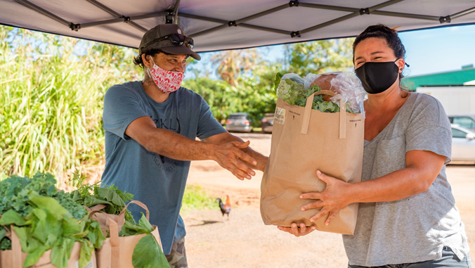 One person handing a package of food to another