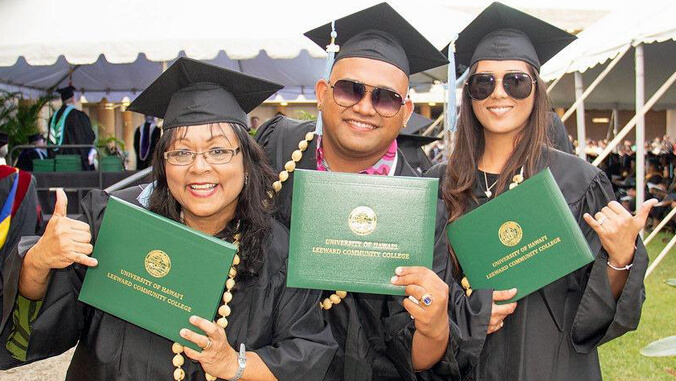 3 people in cap and gown